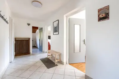 a hallway with white walls and a table in a room at Grand Appartement-Vue Montagne-Wi-Fi-Parking in Magland