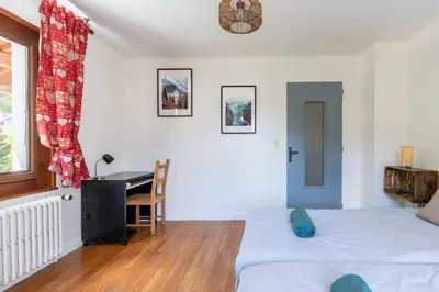 a bedroom with a bed and a desk in it at Grand Appartement-Vue Montagne-Wi-Fi-Parking in Magland