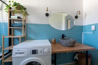 a bathroom with a washing machine and a mirror at Grand Appartement-Vue Montagne-Wi-Fi-Parking in Magland