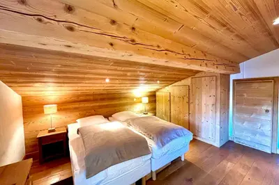 a bedroom with a bed in a wooden room at Charming Alpine Apartment in Megève Mountain View in Megève