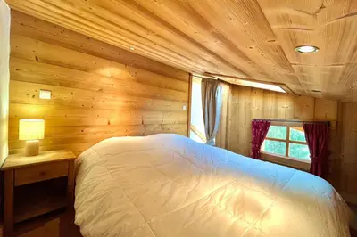 a bedroom with a bed in a wooden cabin at Charming Alpine Apartment in Megève Mountain View in Megève