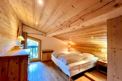 a bedroom with a bed in a wooden room at Charming Alpine Apartment in Megève Mountain View in Megève