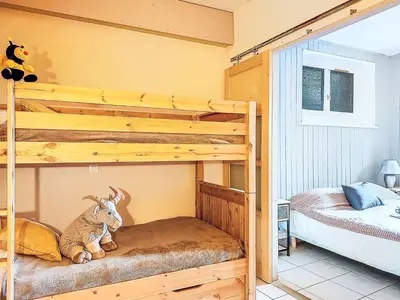 a room with a bunk bed and a red chair at Apartment Au Bon Coin by Interhome in Saint-Gervais-les-Bains
