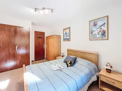 a bedroom with a bed with a blue comforter at Apartment Beaulieu by Interhome in Saint-Gervais-les-Bains