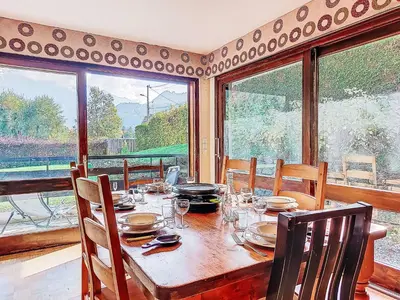 a dining room with a table with chairs and windows at Apartment Beaulieu by Interhome in Saint-Gervais-les-Bains