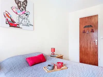 a bed with a red pillow and a tray on it at Apartment Beaulieu by Interhome in Saint-Gervais-les-Bains