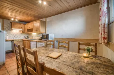 a kitchen with a large wooden table and chairs at Appartements dans le Chalet Nessa - Combloux in Combloux