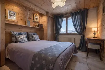 a bedroom with a bed in a room with a window at Appartements dans le Chalet Nessa - Combloux in Combloux