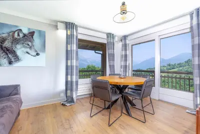 a dining room with a table and a wolf picture on the wall at Appartements dans le Chalet Nessa - Combloux in Combloux