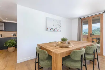 a dining room with a wooden table and chairs at Appartements dans le Chalet Nessa - Combloux in Combloux