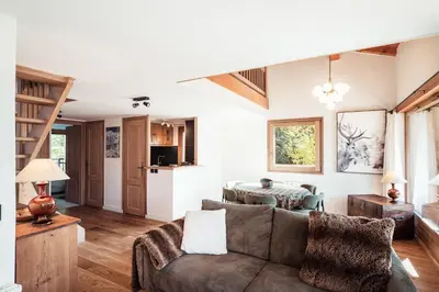 a living room with a couch and a table at Les Cimes d'Eden - Cozy duplex in Megève in Megève