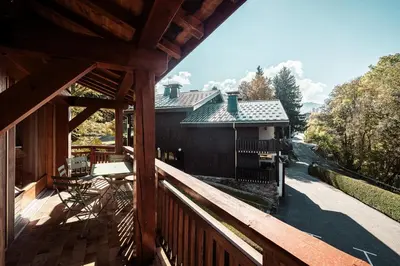 a porch of a house with a wooden deck at Les Cimes d'Eden - Cozy duplex in Megève in Megève