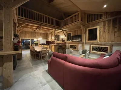 a living room with a red couch and a table at Chalet spacieux à Samoëns, 6 chambres, idéal pour 14 personnes avec Wifi - FR-1-846-1 in Samoëns