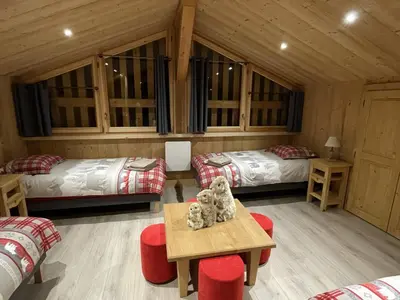 a room with two beds and a table and chairs at Chalet spacieux à Samoëns, 6 chambres, idéal pour 14 personnes avec Wifi - FR-1-846-1 in Samoëns