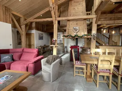 a living room with a red couch and a table at Chalet spacieux à Samoëns, 6 chambres, idéal pour 14 personnes avec Wifi - FR-1-846-1 in Samoëns