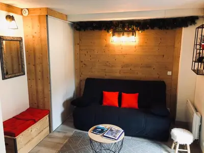 a room with a couch with red pillows and a table at Studio cosy pour 4 à Samoëns - FR-1-846-4 in Samoëns