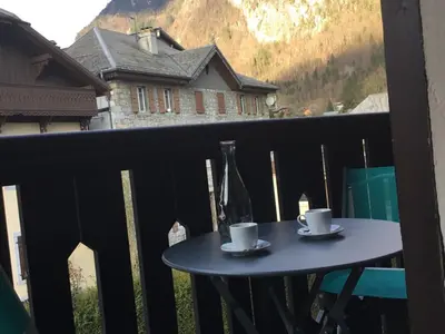 a table with two cups and a bottle of wine on a balcony at Studio cosy pour 4 à Samoëns - FR-1-846-4 in Samoëns