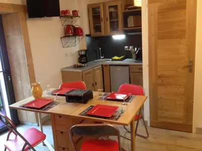 a kitchen with a wooden table and red chairs at Studio cosy pour 4 à Samoëns - FR-1-846-4 in Samoëns