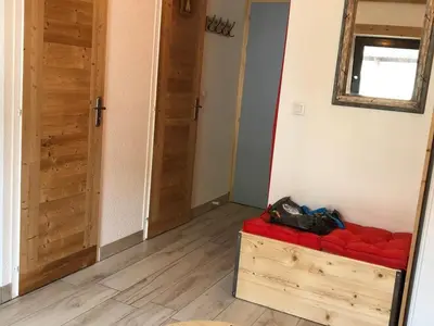 a room with a red couch and two doors at Studio cosy pour 4 à Samoëns - FR-1-846-4 in Samoëns