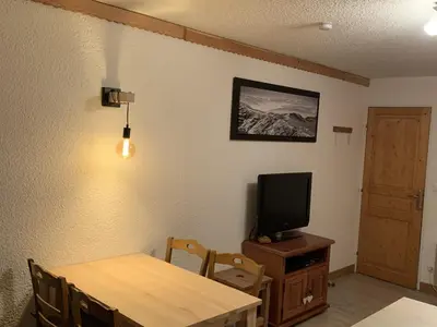 a dining room with a table and a television at Studio confortable à Samoëns 1600 pour 4 personnes - FR-1-846-3 in Samoëns