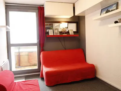 a red chair in a room with a window at Studio confortable pour 5 personnes à Samoëns - FR-1-846-13 in Samoëns