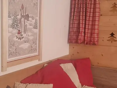 a bedroom with a bed with a red blanket at Appartement cosy avec Wifi à l'orée du bois - FR-1-846-11 in Samoëns