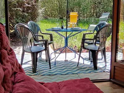 a patio with chairs and a table and a table at Appartement cosy avec Wifi à l'orée du bois - FR-1-846-11 in Samoëns