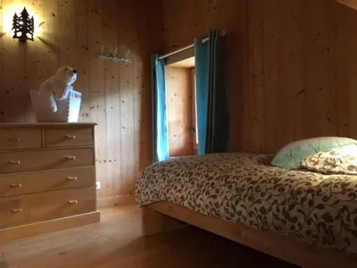 a bedroom with a bed and a dresser in a room at Grand chalet à Samoëns pour 11 personnes avec Wifi - FR-1-846-7 in Samoëns