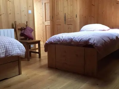 a bedroom with a bed and a wooden wall at Grand chalet à Samoëns pour 11 personnes avec Wifi - FR-1-846-7 in Samoëns