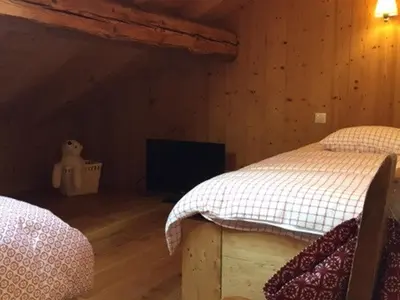 a bedroom with two beds and a flat screen tv at Grand chalet à Samoëns pour 11 personnes avec Wifi - FR-1-846-7 in Samoëns