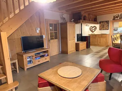 a living room with a television and a table at Grand chalet à Samoëns pour 11 personnes avec Wifi - FR-1-846-7 in Samoëns