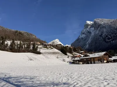 a snow covered village with a mountain in the background at Grand chalet à Samoëns pour 11 personnes avec Wifi - FR-1-846-7 in Samoëns