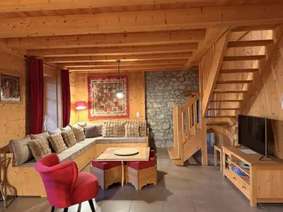a living room with a couch and a tv and stairs at Grand chalet à Samoëns pour 11 personnes avec Wifi - FR-1-846-7 in Samoëns