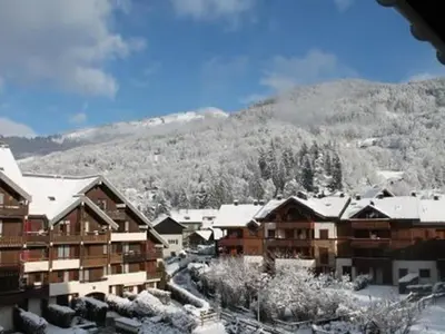 a ski resort with snow covered buildings and a mountain at Studio cosy pour 4 à Samoëns - FR-1-846-22 in Samoëns