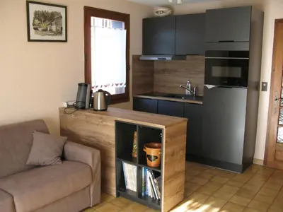 a living room with a couch and a kitchen at Appartement à Samoëns avec Wifi, idéal pour 3 pers. - FR-1-846-23 in Samoëns