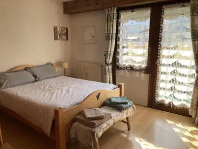 a bedroom with a large bed with a wooden frame at Appartement cosy pour 2 avec Wifi à Samoëns - FR-1-846-27 in Samoëns