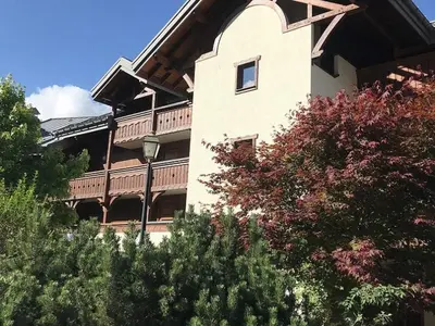 a building with a balcony and trees in front of it at Charmant appartement avec WiFi à Samoëns - FR-1-846-20 in Samoëns