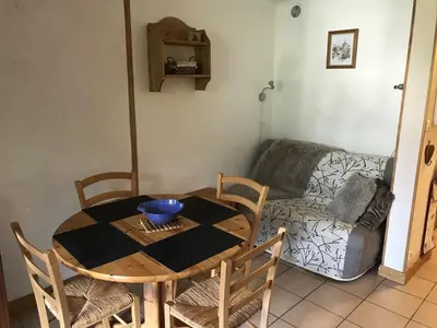 a room with a table and chairs and a couch at Charmant appartement avec WiFi à Samoëns - FR-1-846-20 in Samoëns