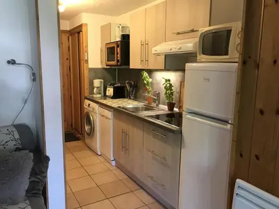 a kitchen with a white refrigerator and a microwave at Charmant appartement avec WiFi à Samoëns - FR-1-846-20 in Samoëns