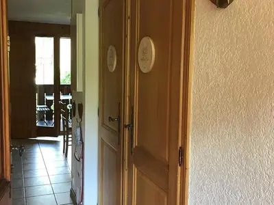 a door in a room with a clock on the wall at Charmant appartement avec WiFi à Samoëns - FR-1-846-20 in Samoëns