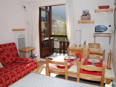 a living room with a red couch and a table at Studio cosy pour 4 personnes à Samoëns - FR-1-846-31 in Samoëns