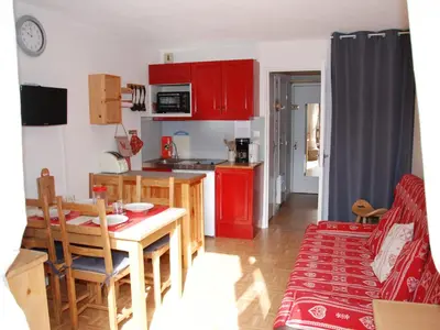 a kitchen with red cabinets and a table and a dining room at Studio cosy pour 4 personnes à Samoëns - FR-1-846-31 in Samoëns