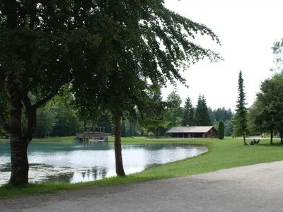 a park with a lake and a building and trees at Studio cosy pour 4 personnes à Samoëns - FR-1-846-31 in Samoëns