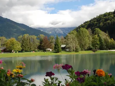 a view of a lake with flowers in the foreground at Studio cosy pour 4 personnes à Samoëns - FR-1-846-31 in Samoëns