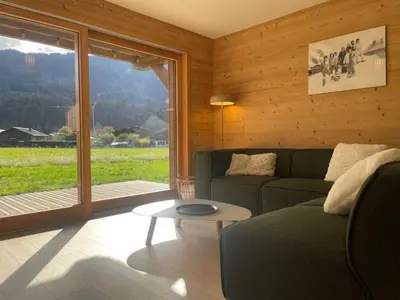 a living room with a couch and a large window at Appartement spacieux à Samoëns - 8 personnes avec Wifi - FR-1-846-38 in Samoëns