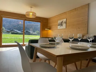 a dining room with a table with wine glasses on it at Appartement spacieux à Samoëns - 8 personnes avec Wifi - FR-1-846-38 in Samoëns