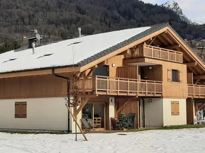 a large wooden house in the snow with a mountain at Appartement spacieux à Samoëns - 8 personnes avec Wifi - FR-1-846-38 in Samoëns