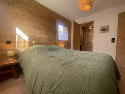 a bedroom with a large bed in a wooden wall at Appartement spacieux à Samoëns - 8 personnes avec Wifi - FR-1-846-38 in Samoëns