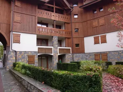 a snow covered building with a mountain in the background at Charmant appartement à Samoëns avec wifi et draps inclus - FR-1-846-30 in Samoëns