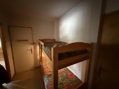 a bunk bed in a small room with a door at Appartement cosy 1 chambre - Samoëns - Wifi - FR-1-846-25 in Samoëns